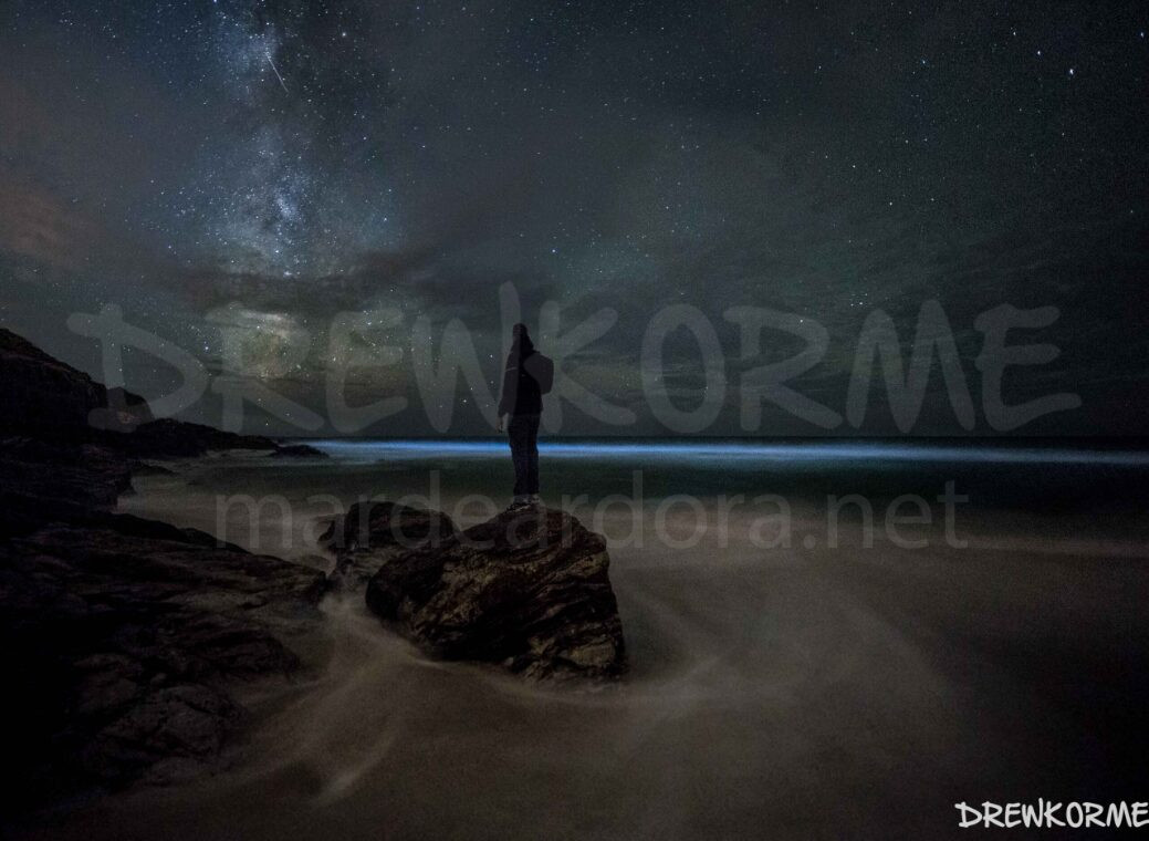 via-lactea-mar-de-ardora-mar-de-fora-fisterra-costa-da-morte-galicia-drewkorme Mar de ardora y Vía Láctea en la playa de Mar de Fora en Fisterra, Costa da Morte (Galicia), con una persona sobre las rocas observando el cielo nocturno
